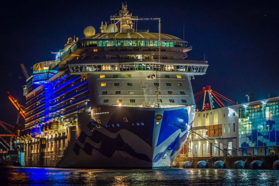 Beleuchtetes Kreuzfahrtschiff nachts am Kai